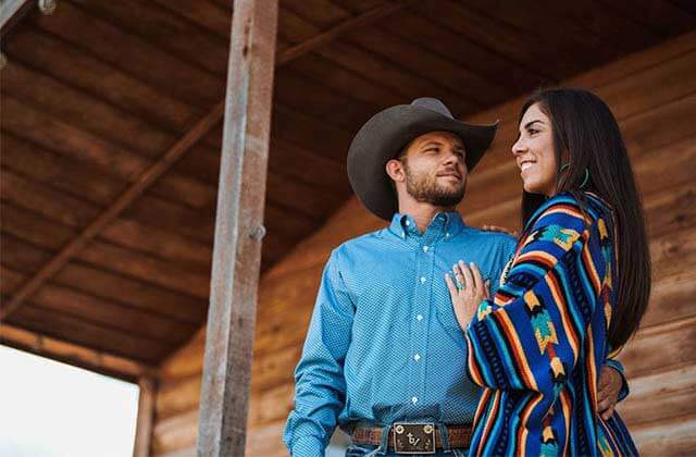 cowboy and cowgirl couple standing on a porch for cavenders western wear orlando