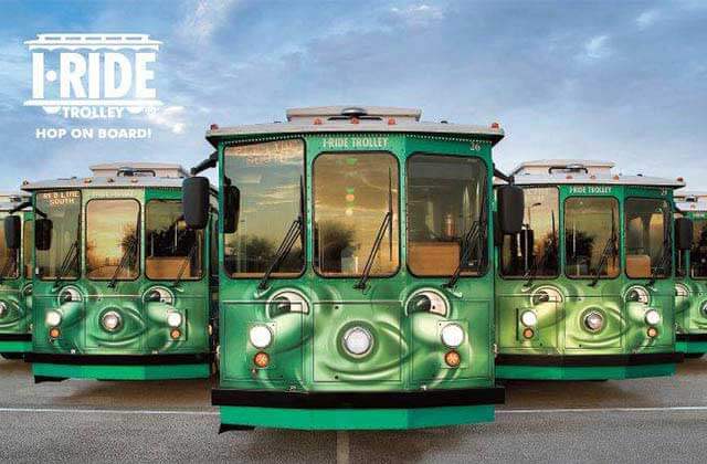 fleet of green trolleys with logo for i-ride trolley orlando