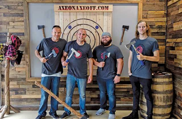four men on staff standing with axes at axe on axe off throwing venue orlando