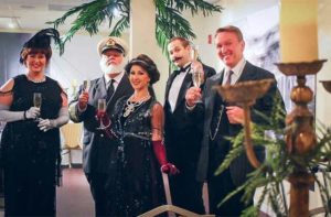 performers in period costume in a dining hall toasting champagne glasses at titanic gala dinner event orlando