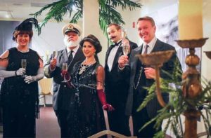 performers in period costume in a dining hall toasting champagne glasses at titanic gala dinner event orlando