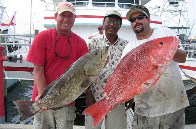 three smiling men standing and holding two huge fish at princess fishing fleet cape canaveral