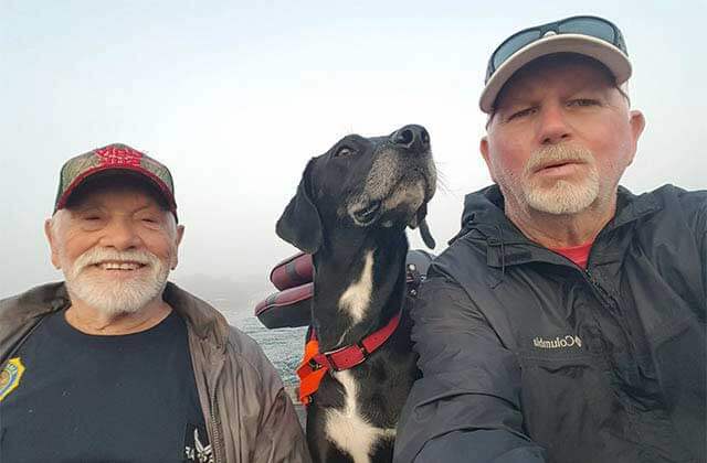 two older men with a dog selfie in a boat at memory makin fishing guides kissimmee