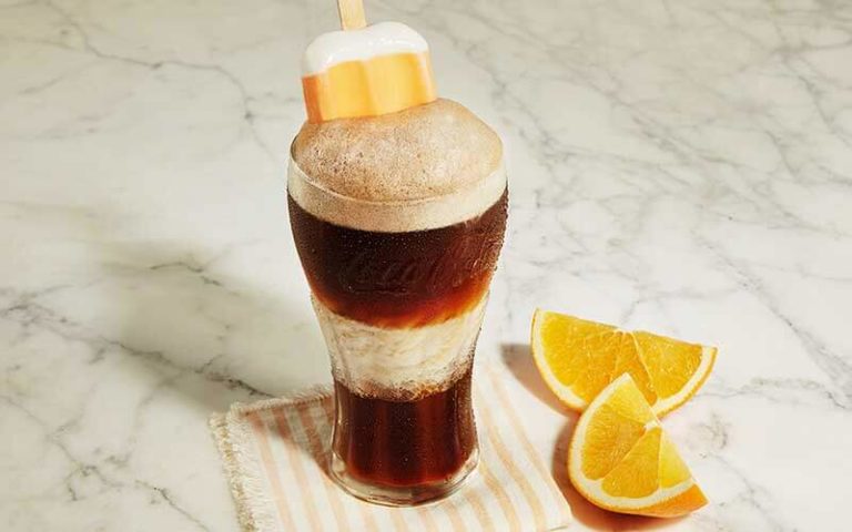 coke float in a glass with oranges and creamsicle at coca cola store at disney springs