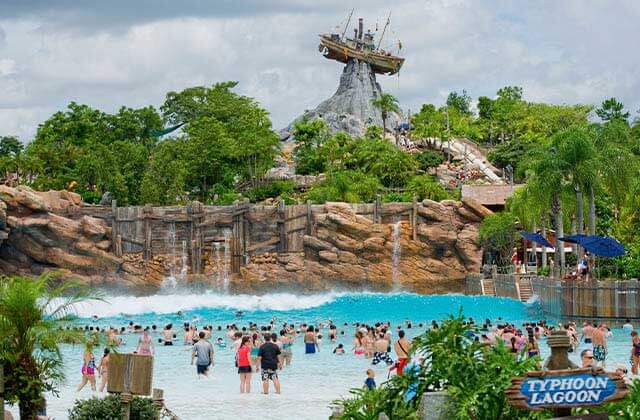 crowded wave pool with shipwreck on mountain top above trees at disneys typhoon lagoon water park
