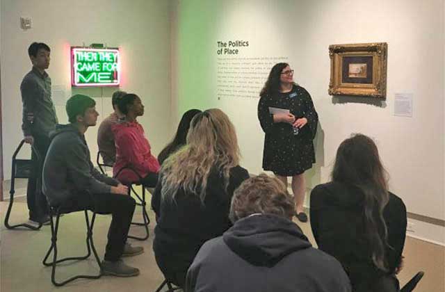 docent presenting art to a seated crowd in a gallery at cornell fine arts museum at rollins college winter park