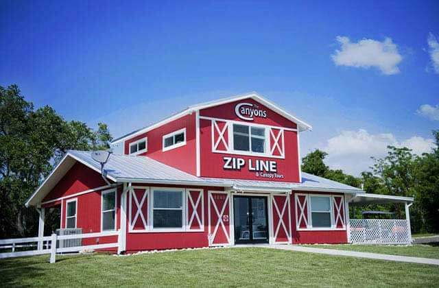front exterior red barn style with signs at the canyons zip line adventure park ocala