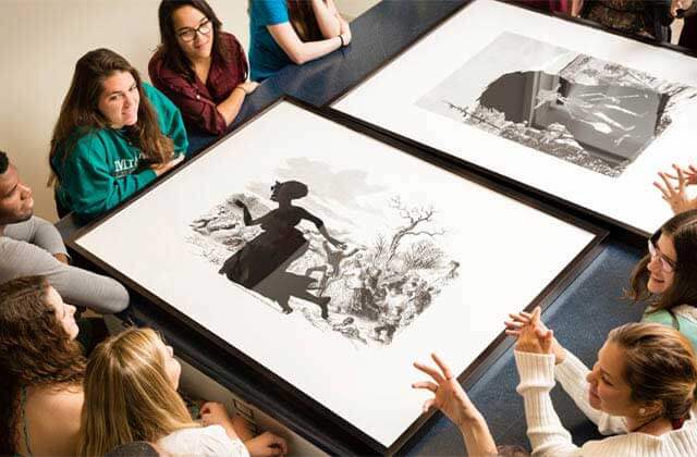 group surrounding a tabletop piece and discussing at cornell fine arts museum at rollins college winter park