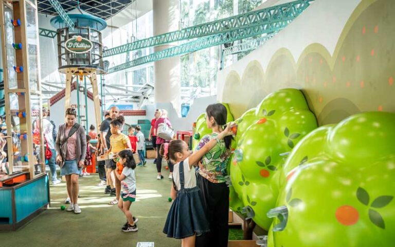 kids interacting with orange picking machine at orlando science center