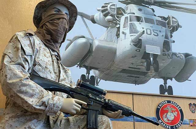 mannequin in uniform holding a service weapon with a military helicopter photo at museum of military history kissimmee