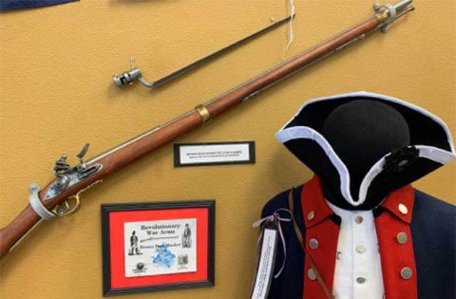a musket and a uniform in a revolutionary war exhibit at museum of military history kissimmee