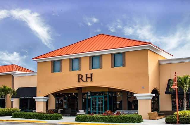 outdoor shopping center with light orange buildings and palm trees with restoration hardware storefront at vero beach outlets space coast florida