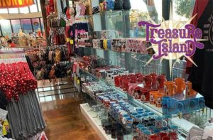 shelves of disney souvenir mugs kids apparel and purses at treasure island gift shop orlando lake buena vista