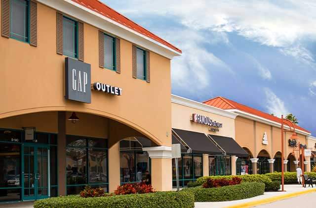 shopping center with brown buildings white columns parking and gap storefront at vero beach outlets space coast florida