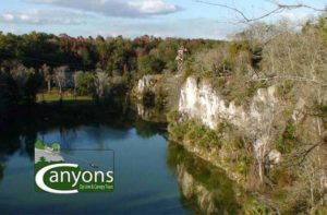view of canyon cliff and trees with zip line tower at the canyons zip line adventure park ocala