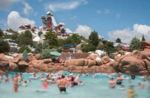 wave pool crowded with ski jump slide above the rocks at disneys blizzard beach water park