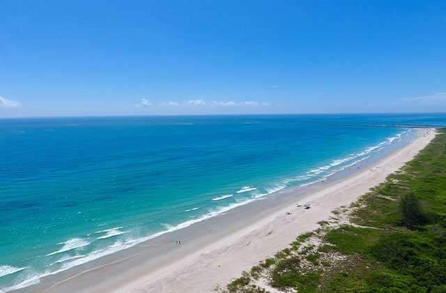 aerial diagonal of shoreline with blue green water and blue sky at st lucie beaches florida