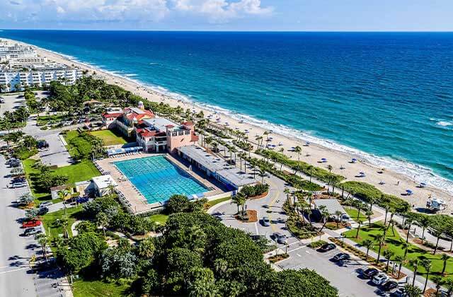 aerial view of a beach with blue water hotels and pool at the palm beaches florida