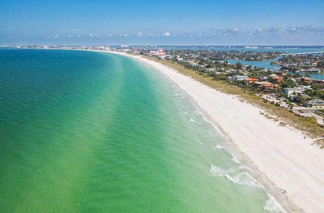 aerial view of green blue ocean along shore with coastal houses at central west beaches