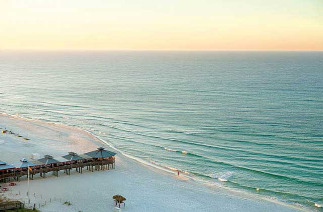 beach sunrise with small pier and white sand at panhandle beaches