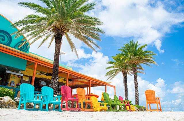 colorful beach chairs with restaurant and palm trees at central west beaches
