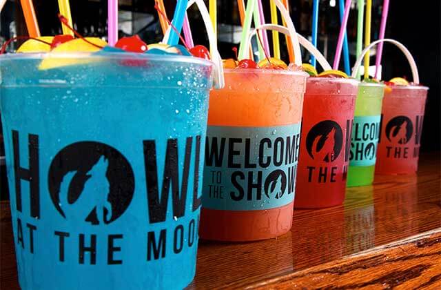 colorful cocktails in buckets with straws and cherries at howl at the moon orlando