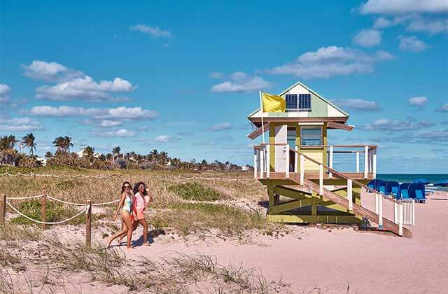pair of ladies walking toward shore past a lifeguard shack at the palm beaches florida
