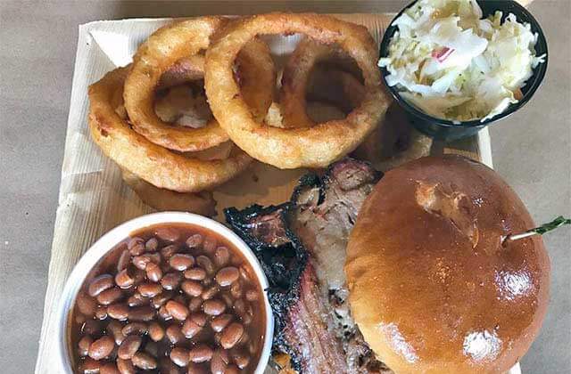 bbq brisket sandwich with beans onion rings and slaw entree at boggy bottom barbecue kissimmee