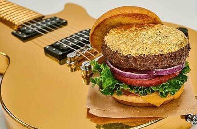 deluxe burger with gold leaf sitting atop a gold guitar at hard rock cafe miami