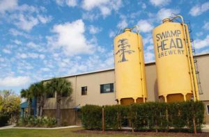 exterior of brewery building with two yellow silos at swamp head brewery gainesville