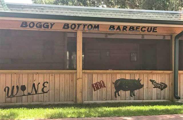 exterior of restaurant with outdoor covered seating with sign at boggy bottom barbecue kissimmee