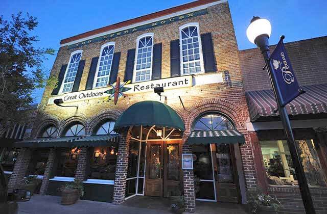 front exterior of brick building with awning at night at the great outdoors restaurant high springs