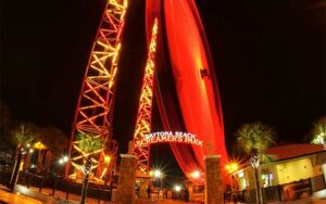 long exposure at night two rides with screamers park sign at daytona beach sling shot