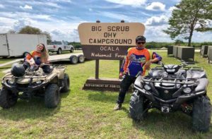 man and woman in racing uniforms on atvs at world adventures ocala