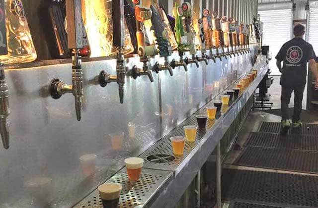row of craft beer taps and samples at miami brewing company