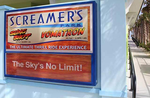 screamers park sign beside sidewalk entrance at slingshot vomatron at screamers park daytona beach