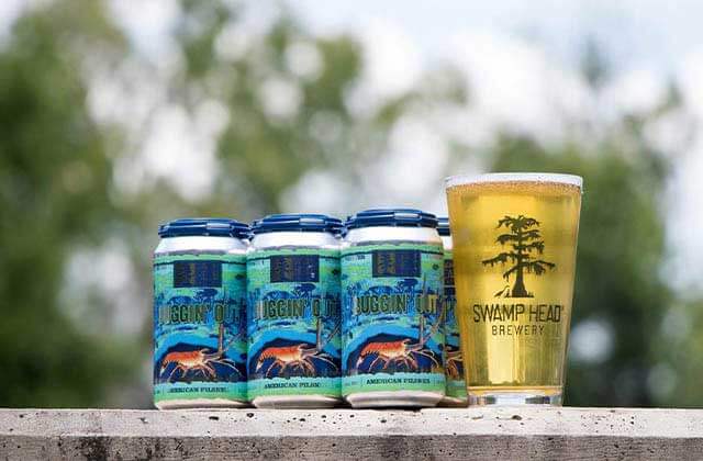six pack of buggin out beer with a glass of pale ale draft at swamp head brewery gainesville