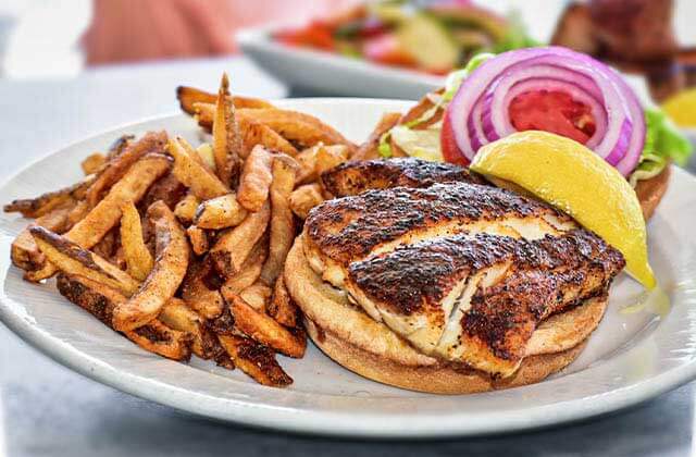 blackened fish burger with sides on a plate at salt cracker fish camp clearwater