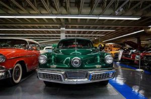 classic cars from 50s and 60s in a warehouse of exhibits at tallahassee automobile museum florida