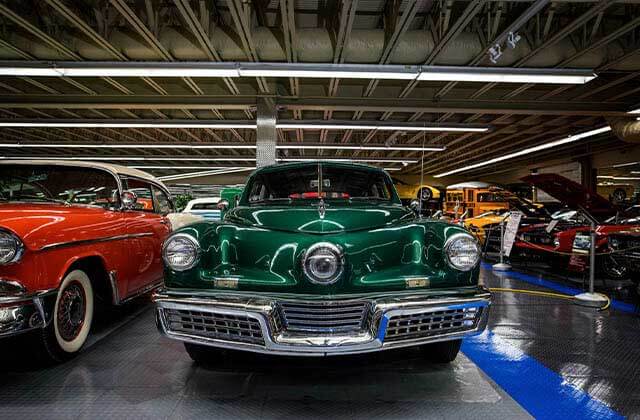 classic cars from 50s and 60s in a warehouse of exhibits at tallahassee automobile museum florida