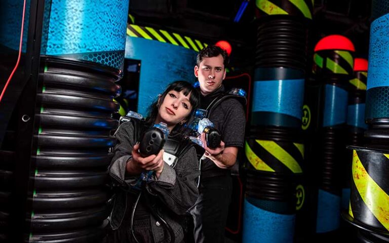 couple playing laser tag in arcade area at wonderworks panama city beach