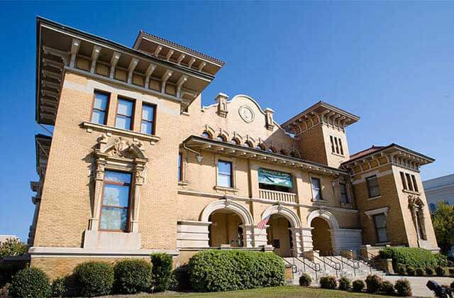 exterior view of greek style brown museum building at historic pensacola tour