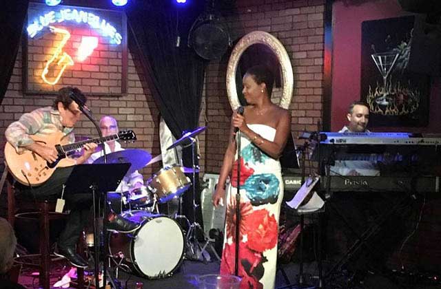 female singer in colorful dress sings with band on stage at blue jean blues fort lauderdale