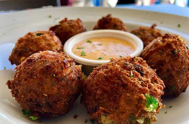 fried hushpuppies with orange sauce on a plate at salt cracker fish camp clearwater