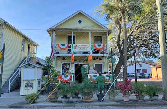 front exterior of two story yellow house with irish flags at ann omalleys irish pub st augustine