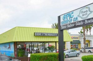 front exterior with sign and green roof and parking at epic beach bar grill cocoa beach