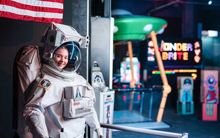 girl posing in astronaut suit in museum area at wonderworks panama city beach
