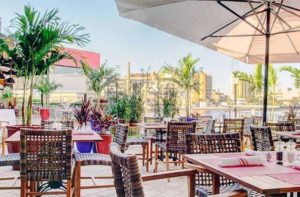 outdoor patio seating with wicker chairs and linen umbrella at american social tampa