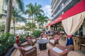 patio seating with palm trees near inlet downtown with red awning at american social miami
