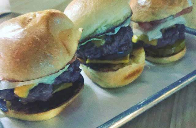 row of three burger sliders on a metal tray at triple b bar grill hollywood florida